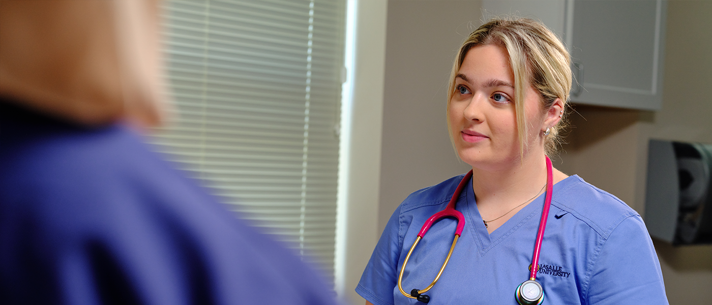 Image of a student and professor working in the nursing sim labs.