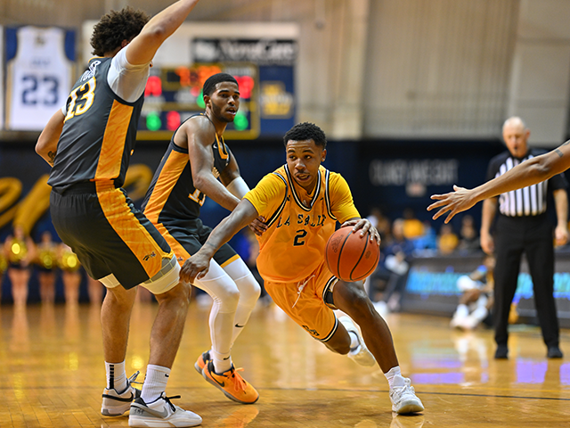 A men's basketball player dribbling and running with the ball.
