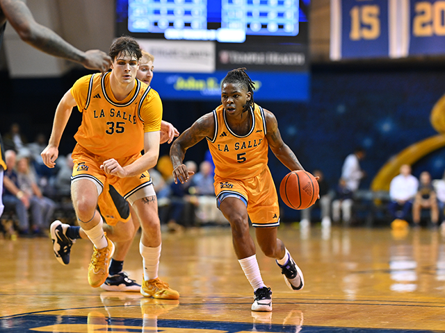 Image of two men's basketball players running down the court.