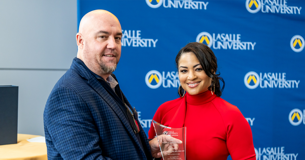 La Salle University Alumni Association President Joe Markmann, Ph.D, ’96, MBA ’06, (left) presented Lisa Abdul-Haqq, DNP, M.A. '09, MSN '21, CRNP, FCPP, (right) with the Women in Leadership Award on March 2, 2024