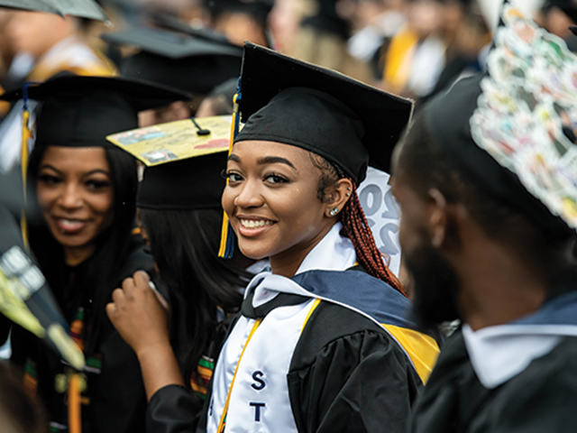 Image of a female student smiling at the camera during Commencement