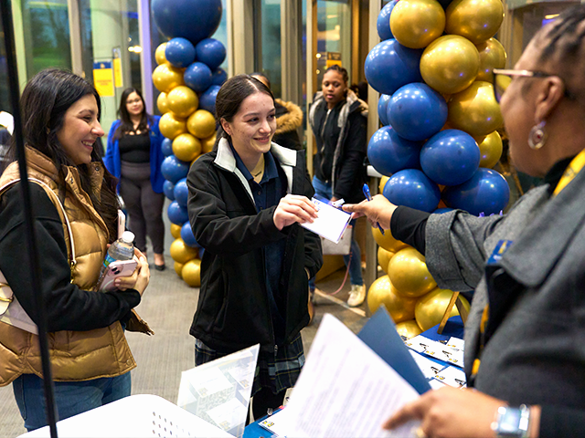 Image of students speaking with an admissions staff member.