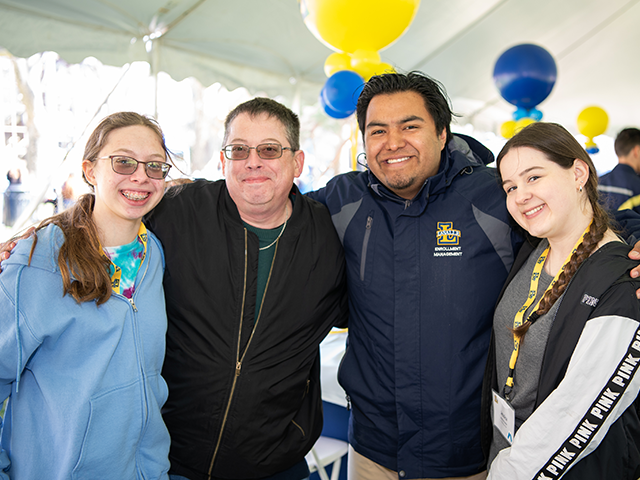 Image of four people posing for a photo at an admitted student day.