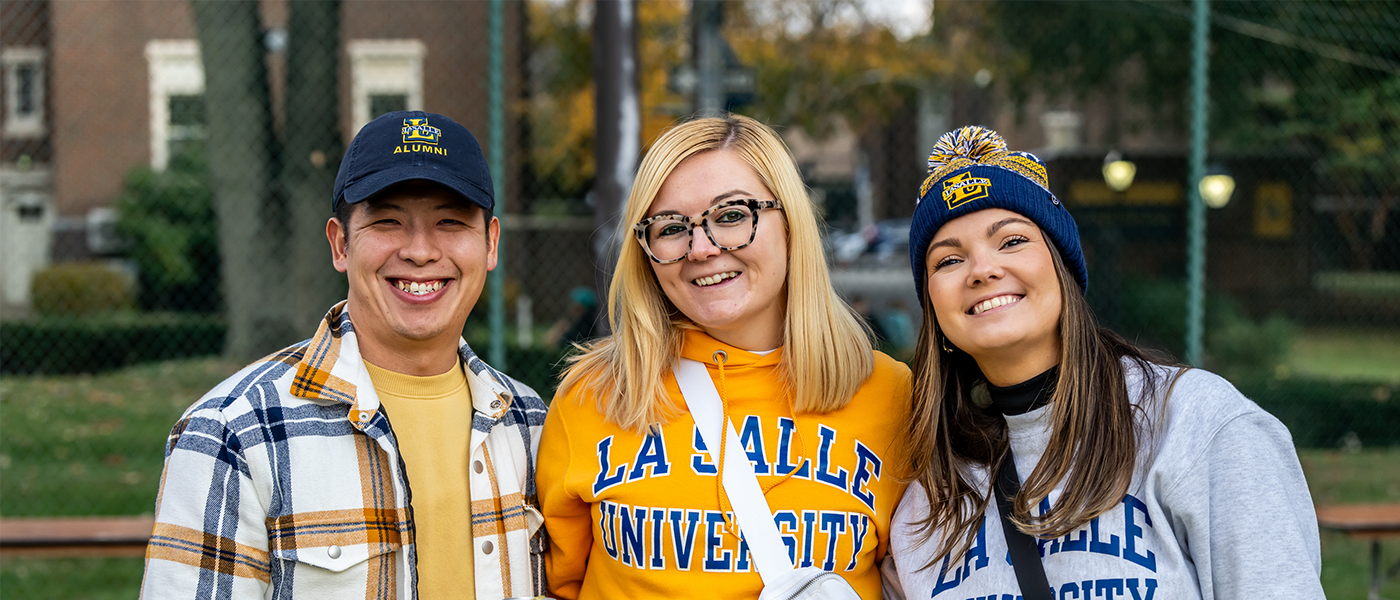 Image of three alumni at Homecoming.