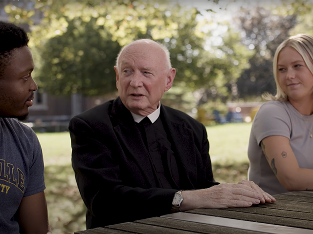 Image of students speaking with a Christian Brother.