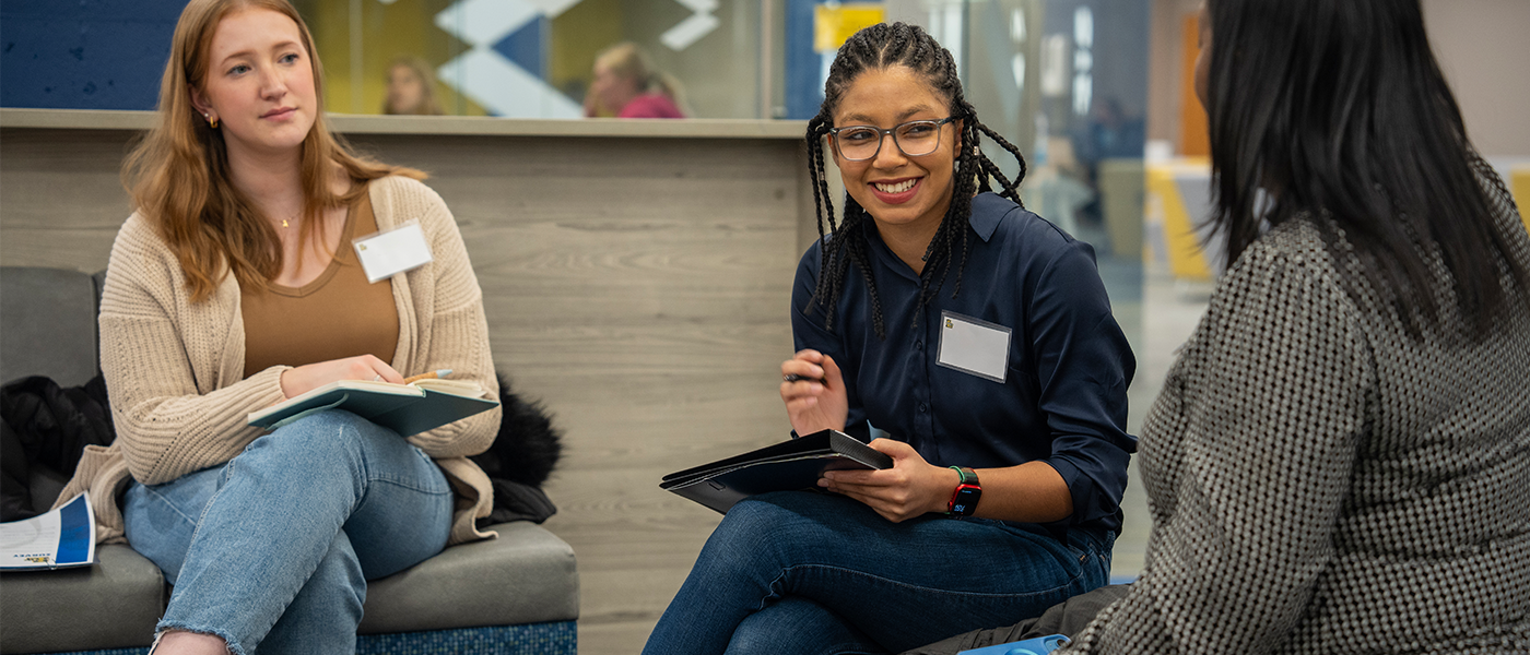 Two students talking to Admissions team member