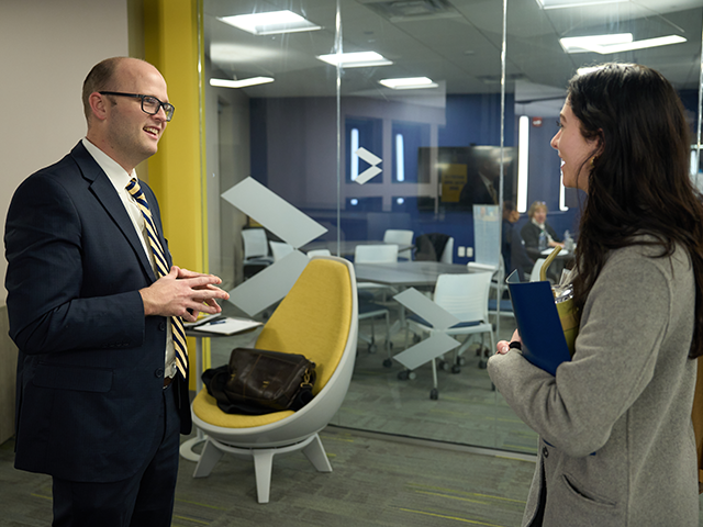 Image of a student speaking with a professor.