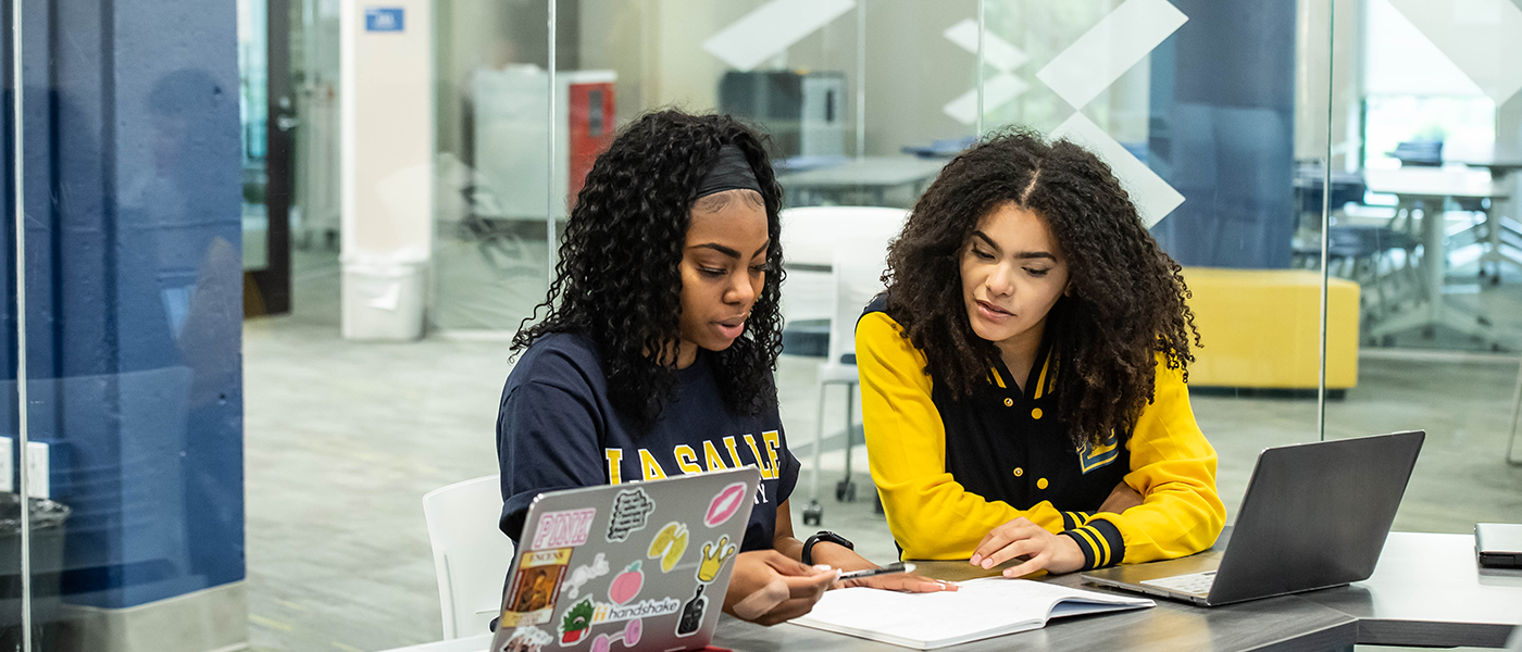 Image of two students looking at homework