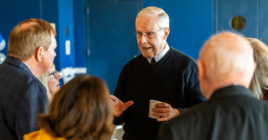 Image of a Christian Brother speaking with alumni