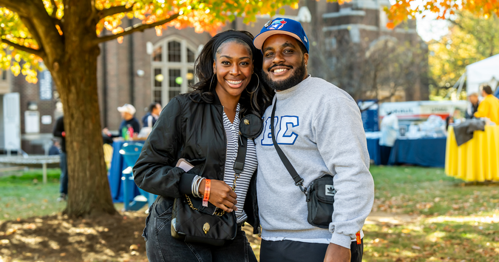 Image of two alumni posing for a photo on the Quad