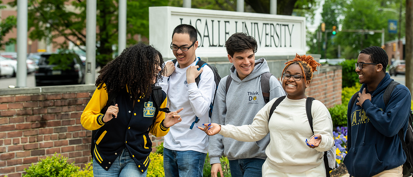 Students walking together and smiling in front of La Salle sign