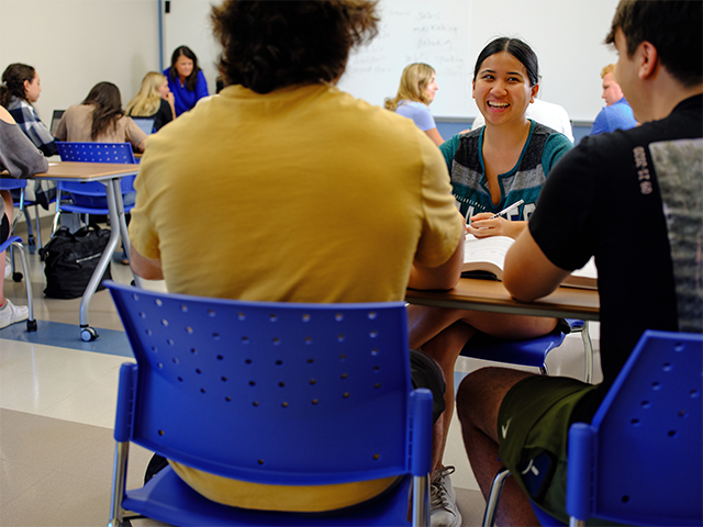 Image of students working in small groups in a classroom